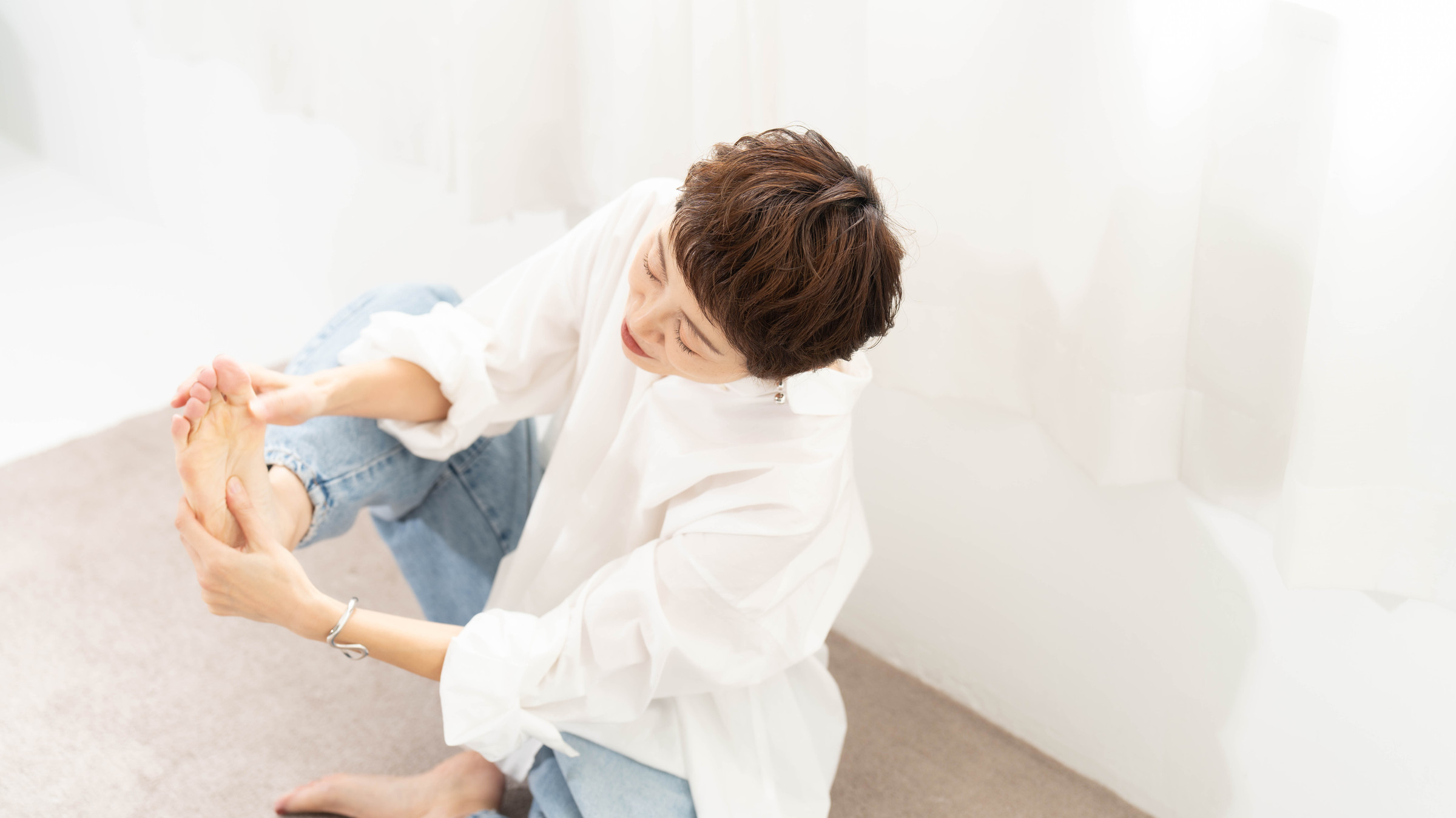 やわらかな光の部屋で、自分の足に触れているよりこ